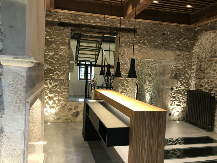 Intérieur réalisé par Studio Deco, murs en pierre et comptoir en bois, éclairage chaleureux